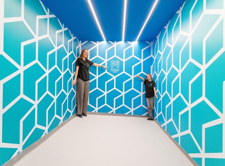 Illusion d'optique de taille dans une pièce bleue au Musée de l'Illusion de Lille, activité ludique et visuelle.