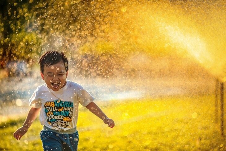 enfant en pleine canicule qui profite de l'eau